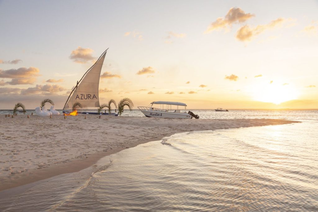 Sunsets over Bazaruto island with a dhow and fire on the beach