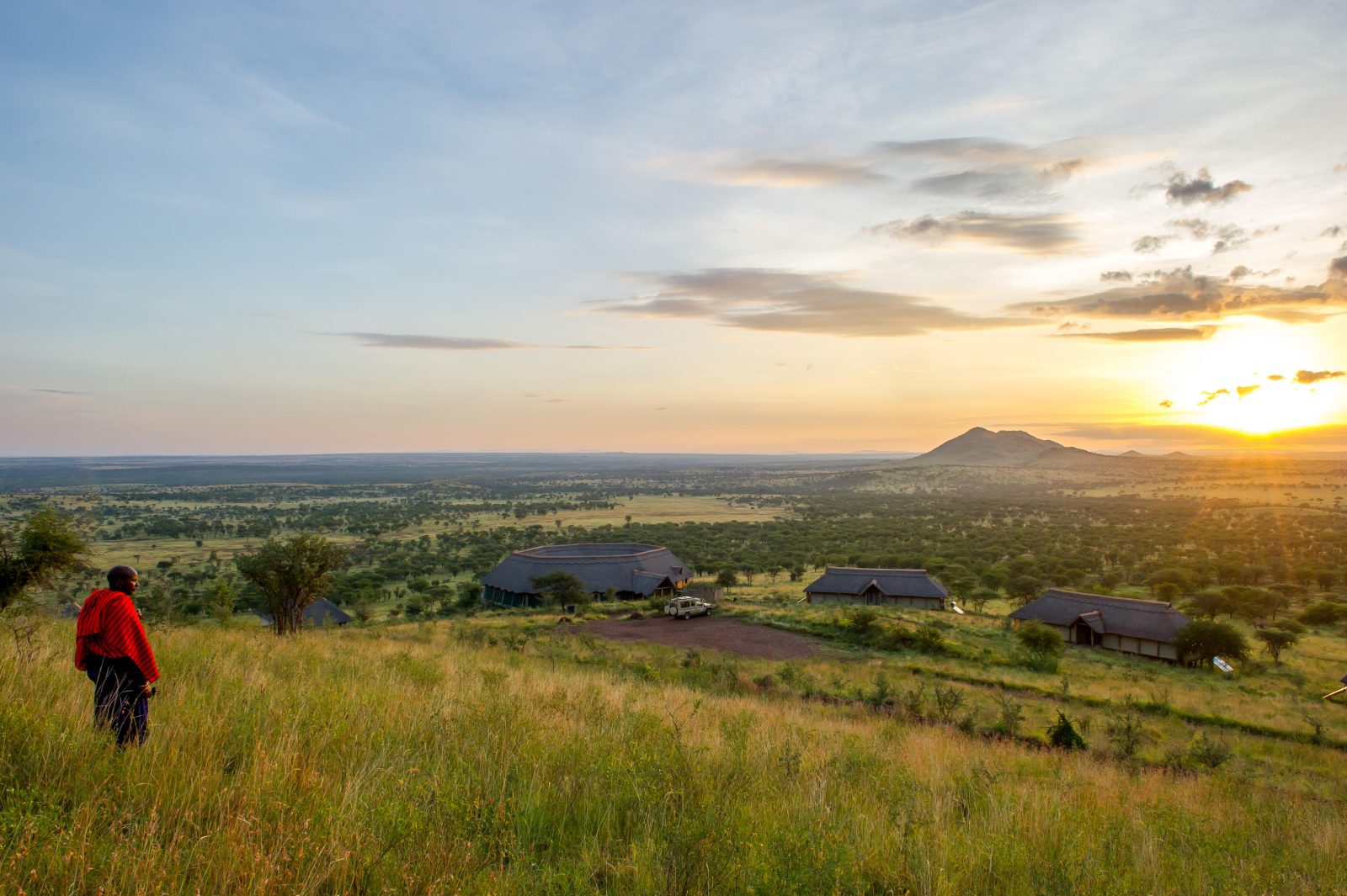 Maasai warrior looks out over the Serengeti from Kubu Kubu Tented Lodge